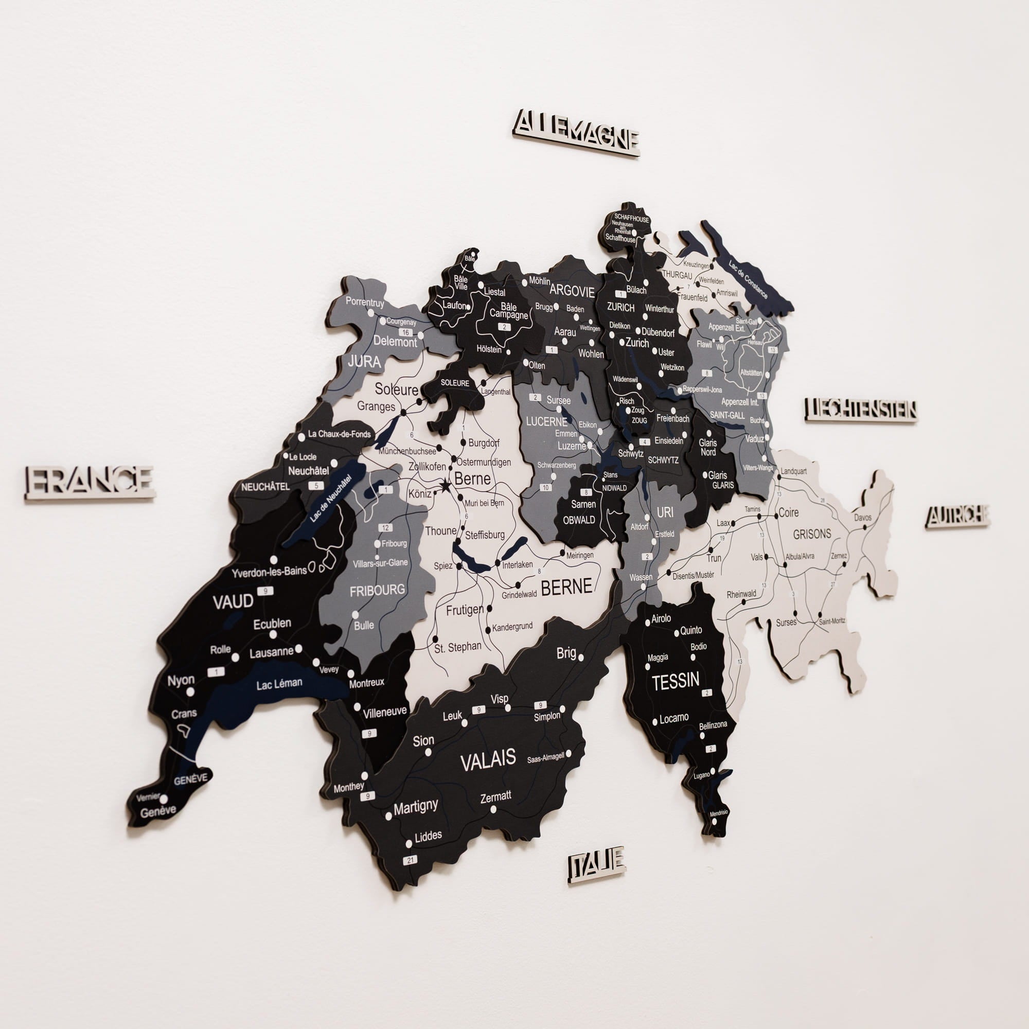 Wooden map of Switzerland with regions labeled on a white background