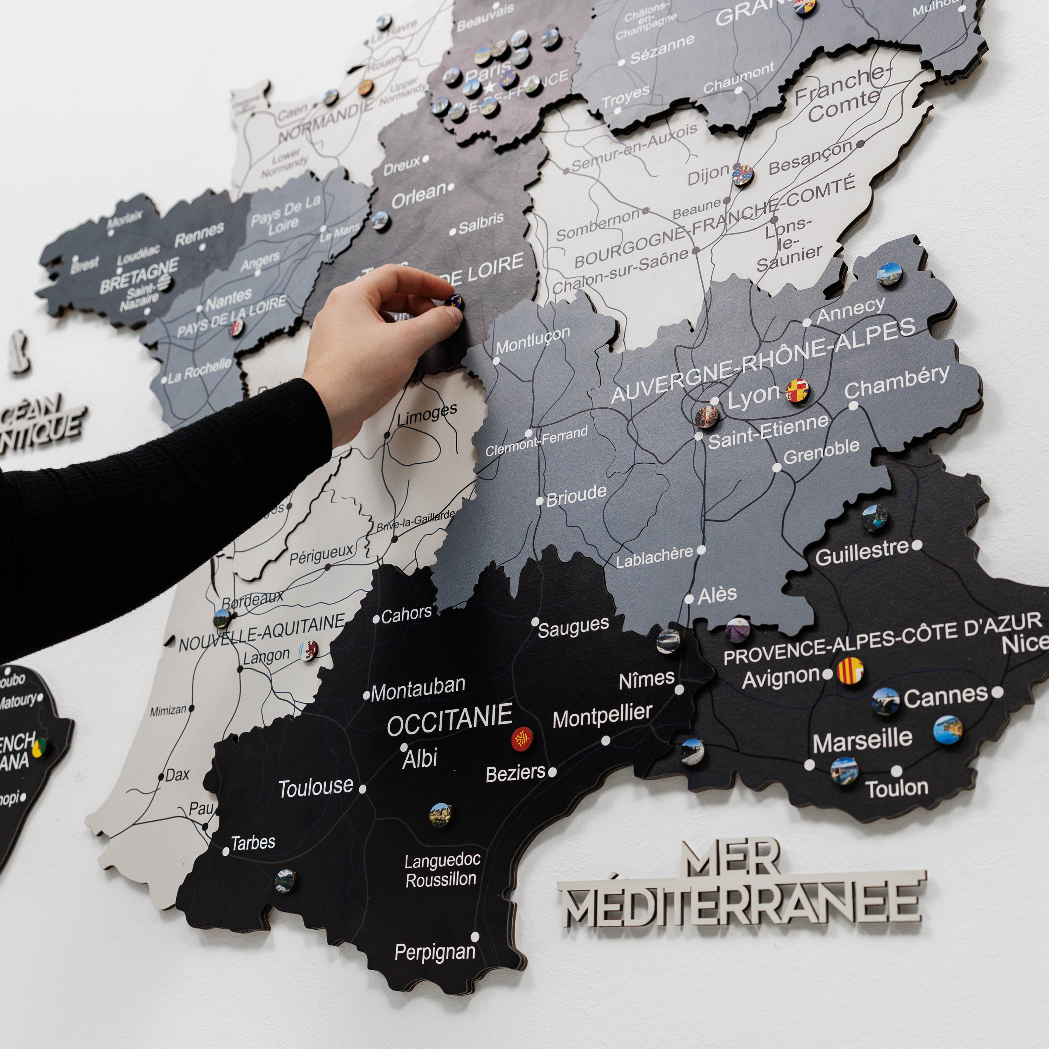Woman interacting with a wall-mounted map of France
