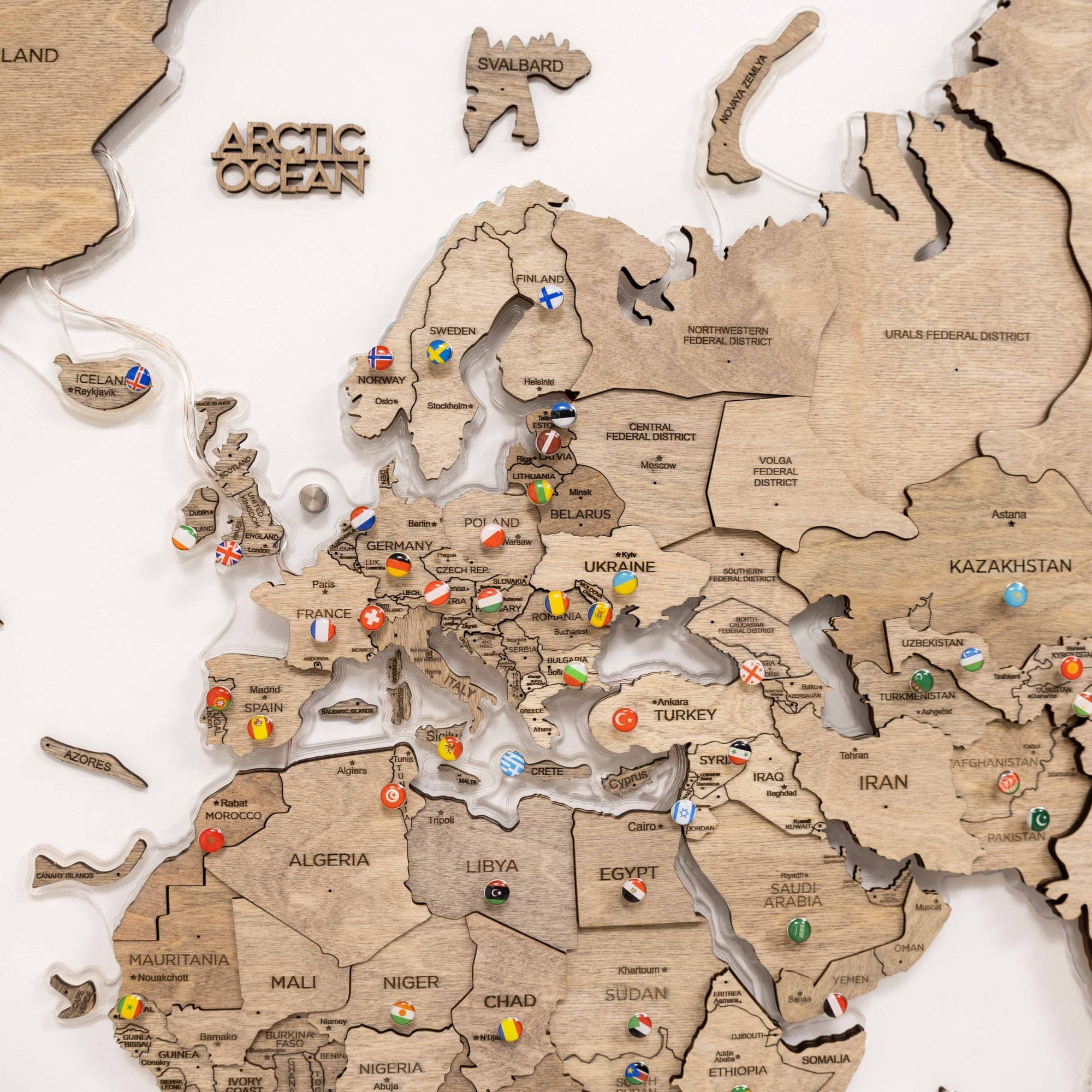 Wooden world map with country names and flags on a white background