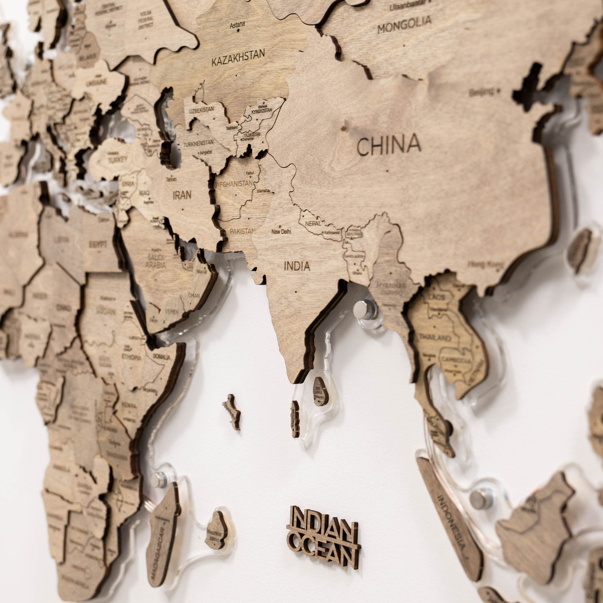 Wooden world map with cut-out countries on a white background