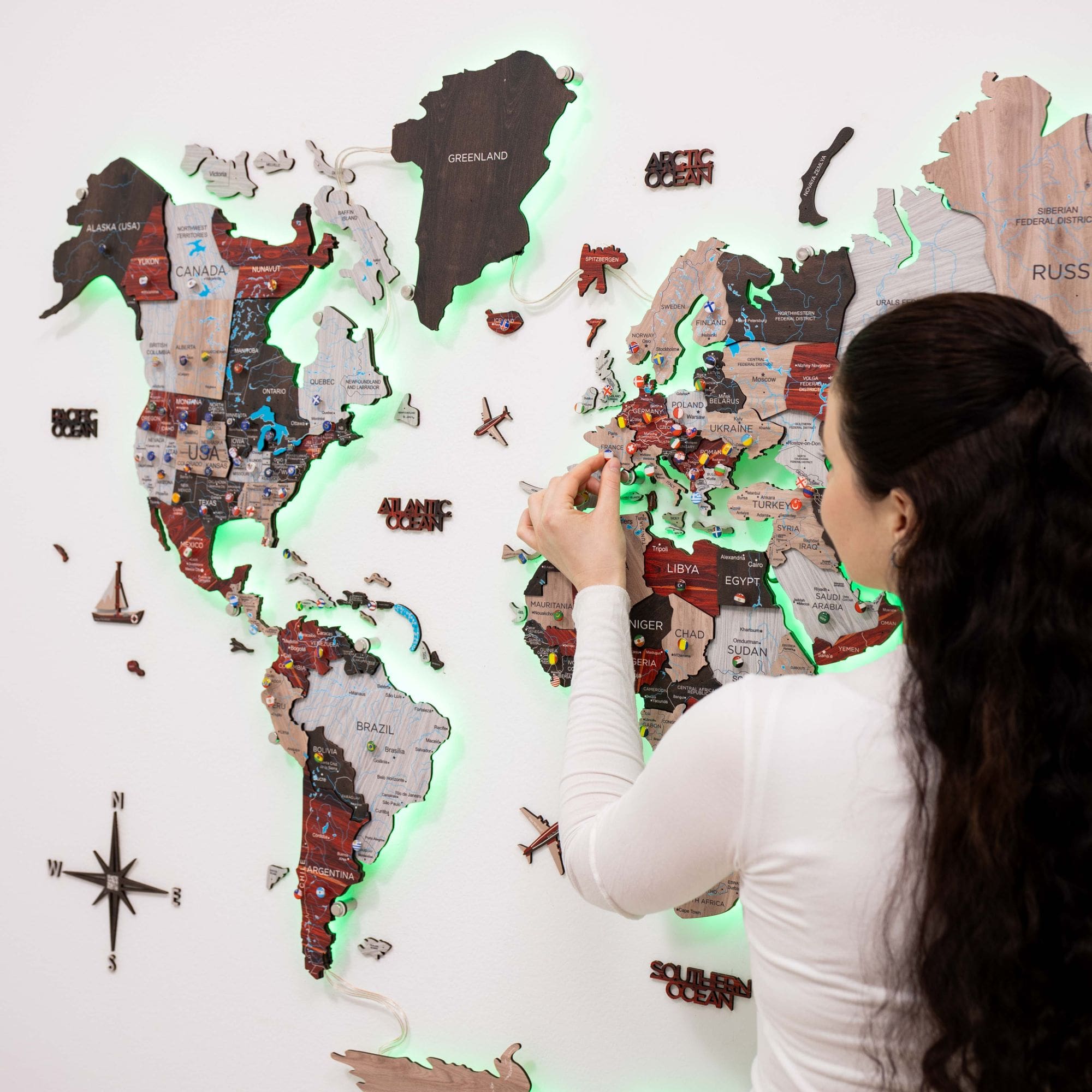 Woman interacting with a world map display on a wall