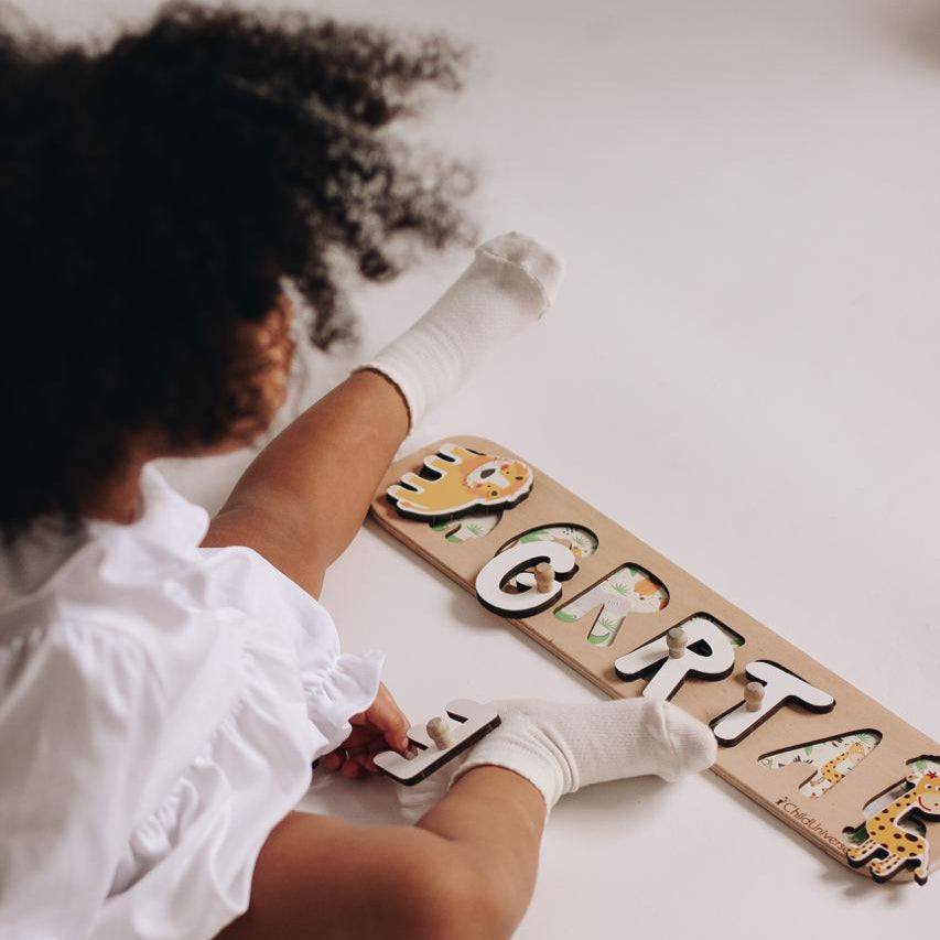Child playing with wooden letters on a white floor