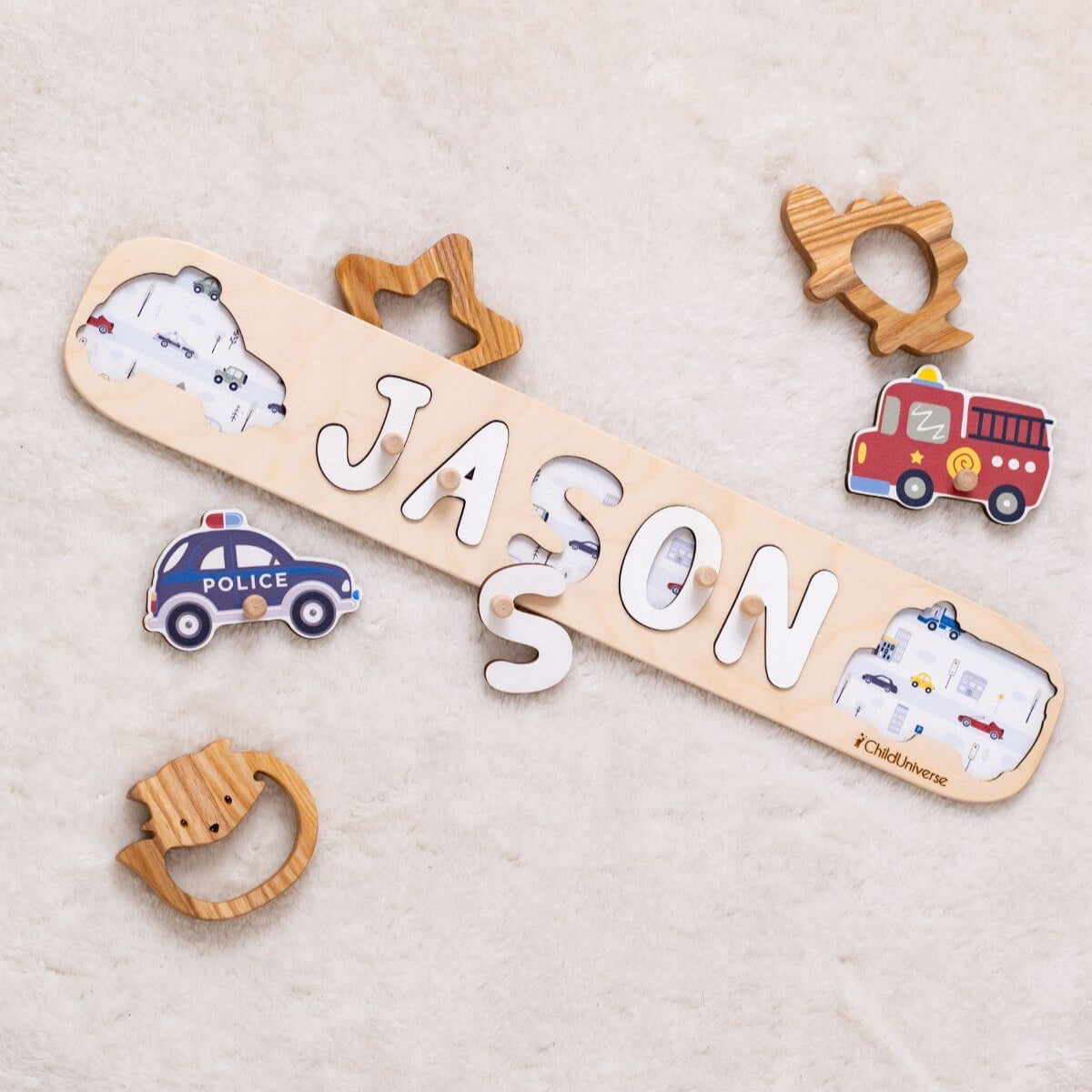 Wooden nameplate with 'JASON' and toy car, truck, and animal shapes on a beige background