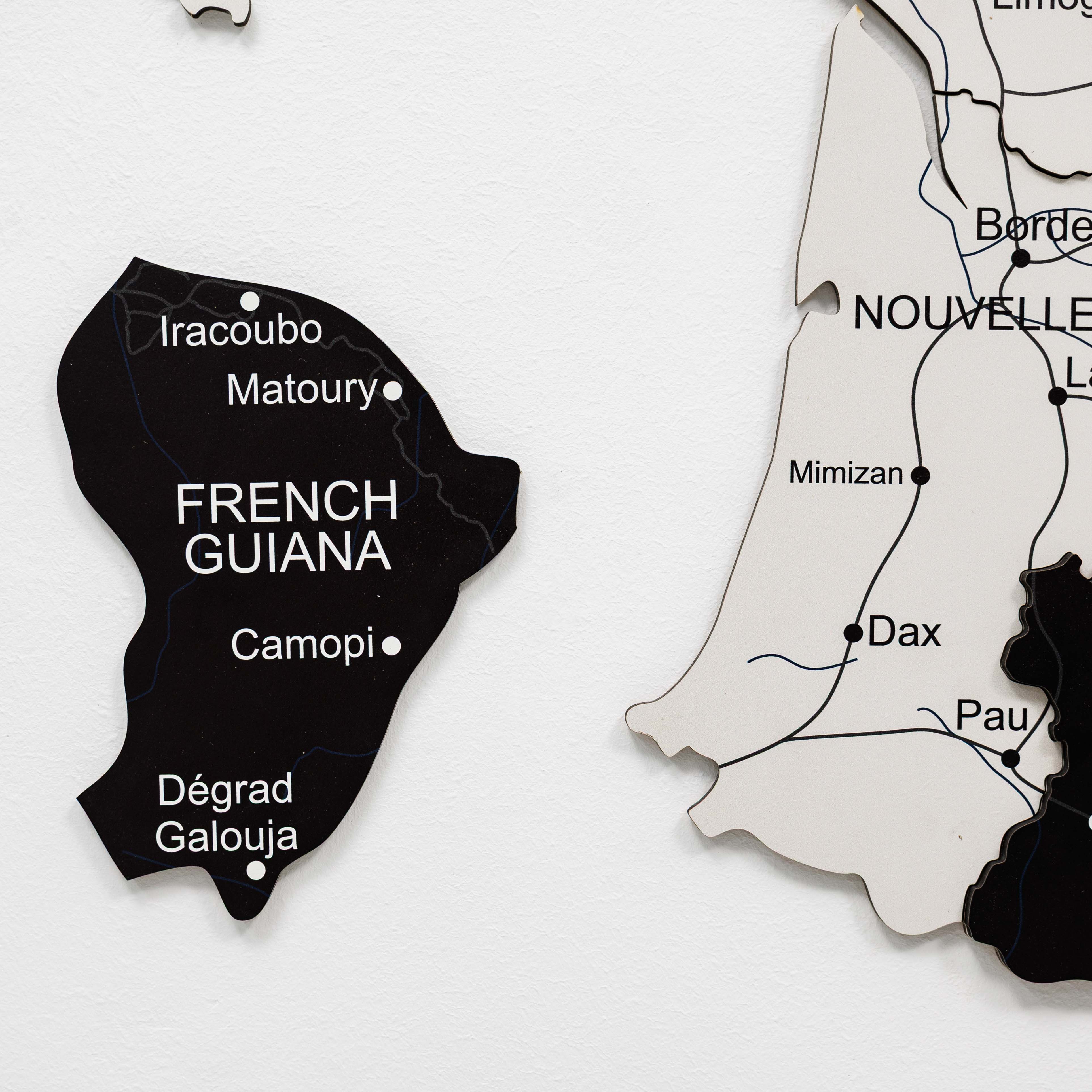 Woman interacting with a wall-mounted map of France