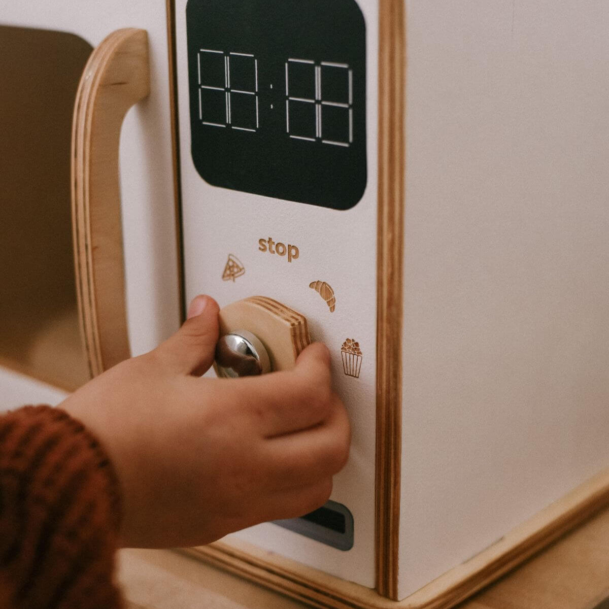 Montessori wooden play microwave with digital display and control knob.