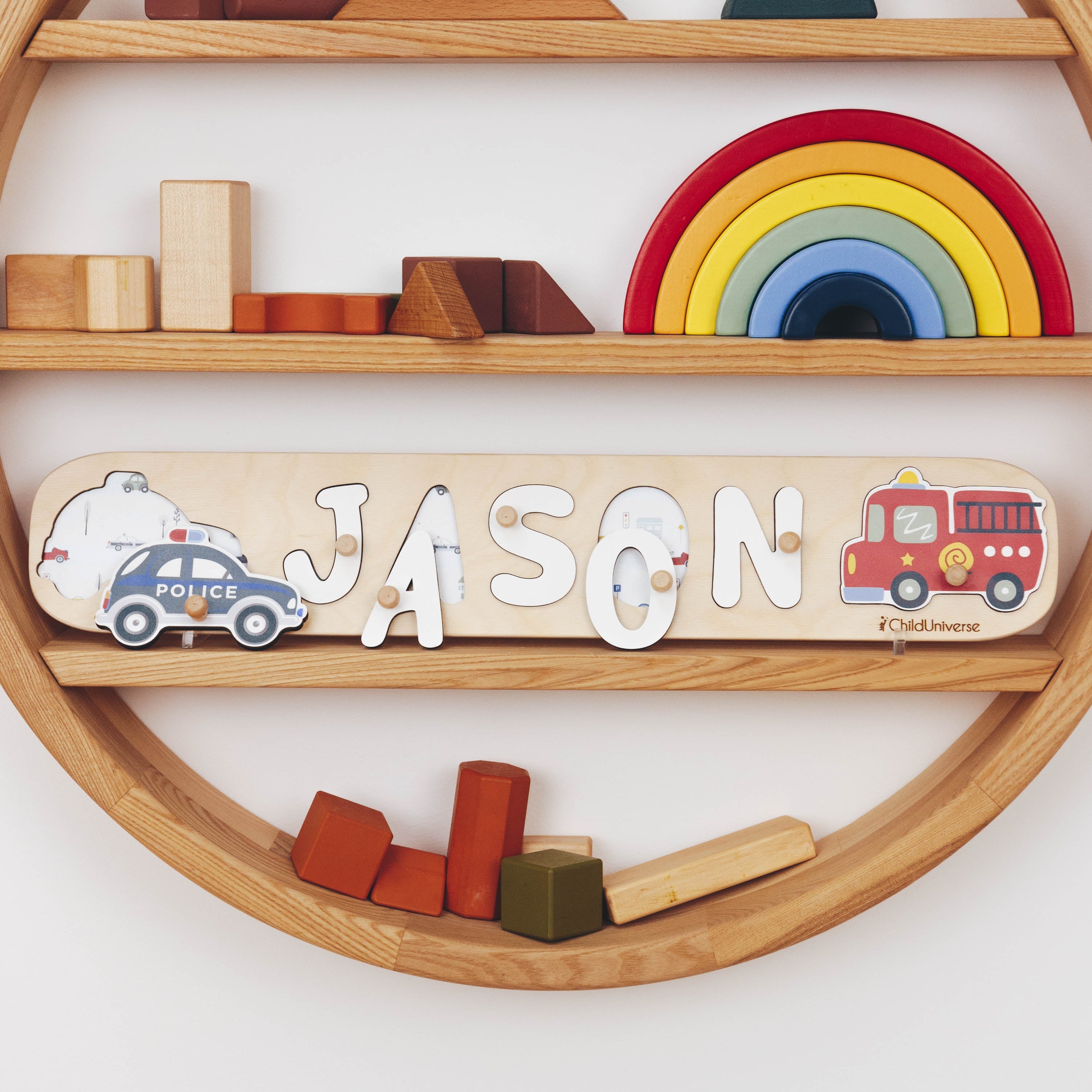 Wooden shelf with toys and a nameplate spelling 'JASON' on a white wall.